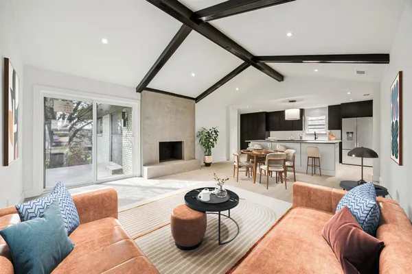a living room with furniture kitchen view and a fireplace