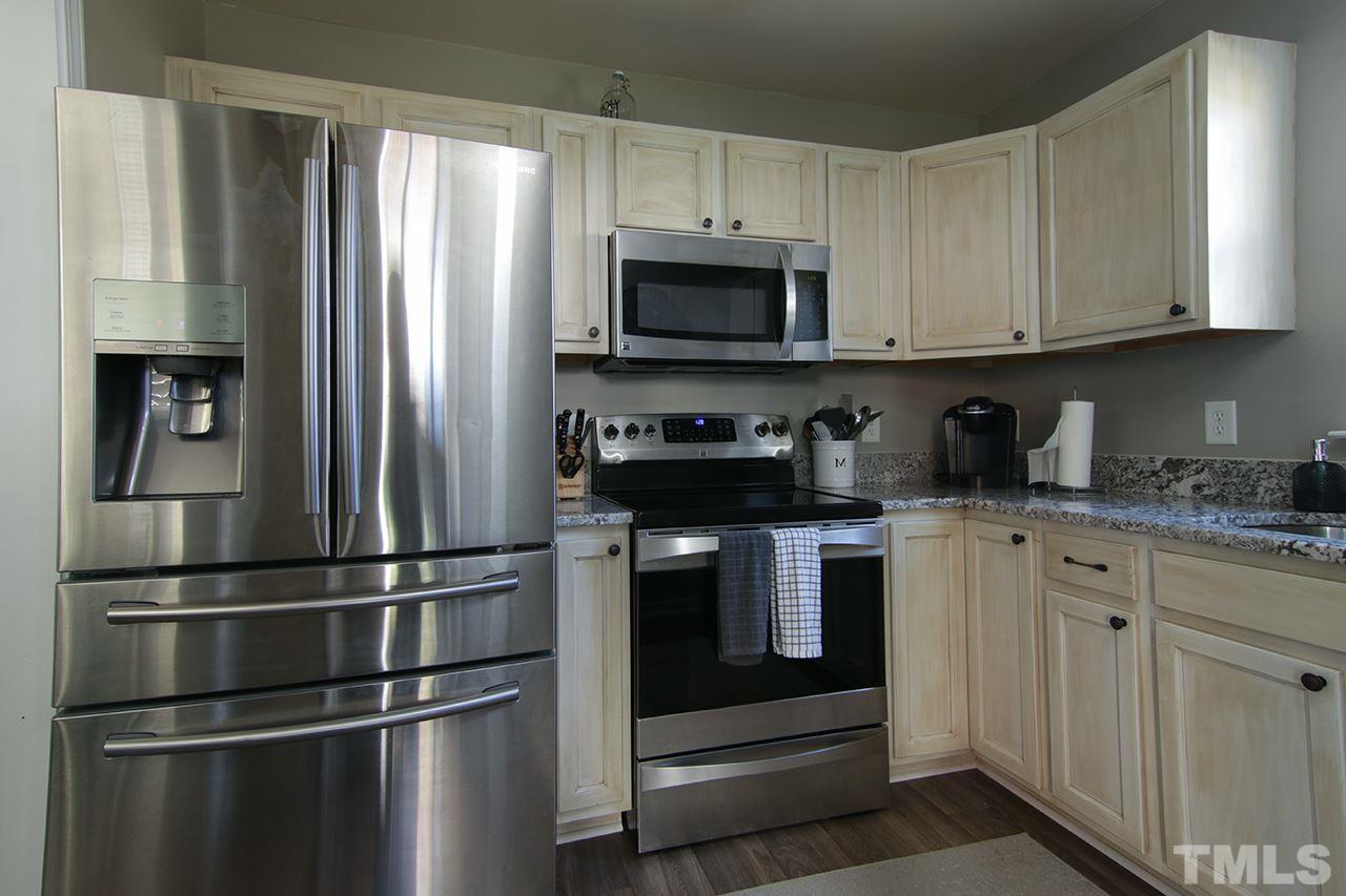 9820 Layla Avenue Raleigh, NC 27617 - Photo 3 of 17 a kitchen with stainless steel appliances granite countertop a refrigerator and a stove top oven