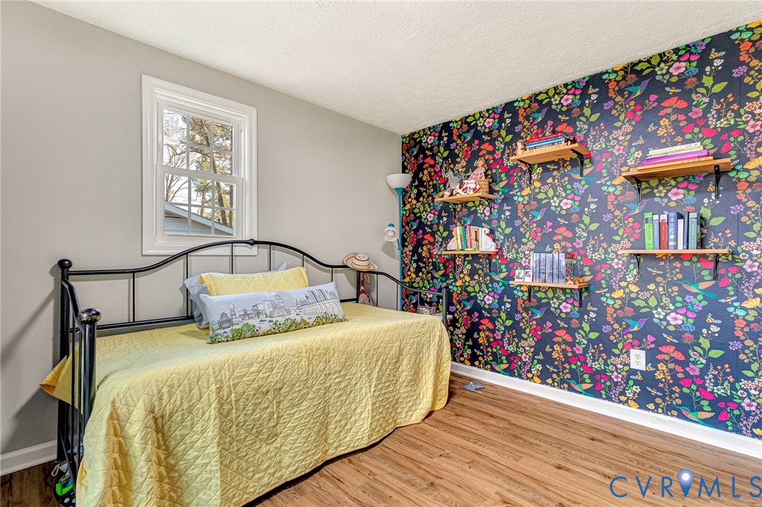 16004 Gary Avenue Chester, VA 23831 - Photo 18 of 26 a bed sitting in a bedroom next to a small yard