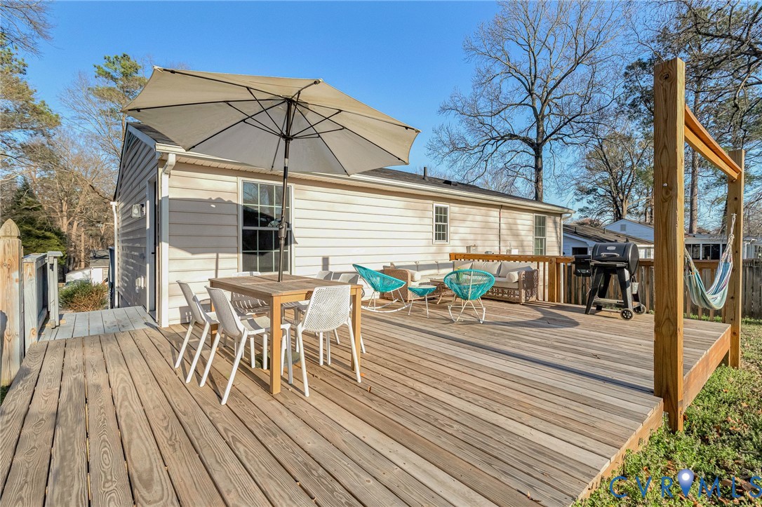 16004 Gary Avenue Chester, VA 23831 - Photo 26 of 26 a view of a roof deck with table and chairs and wooden floor