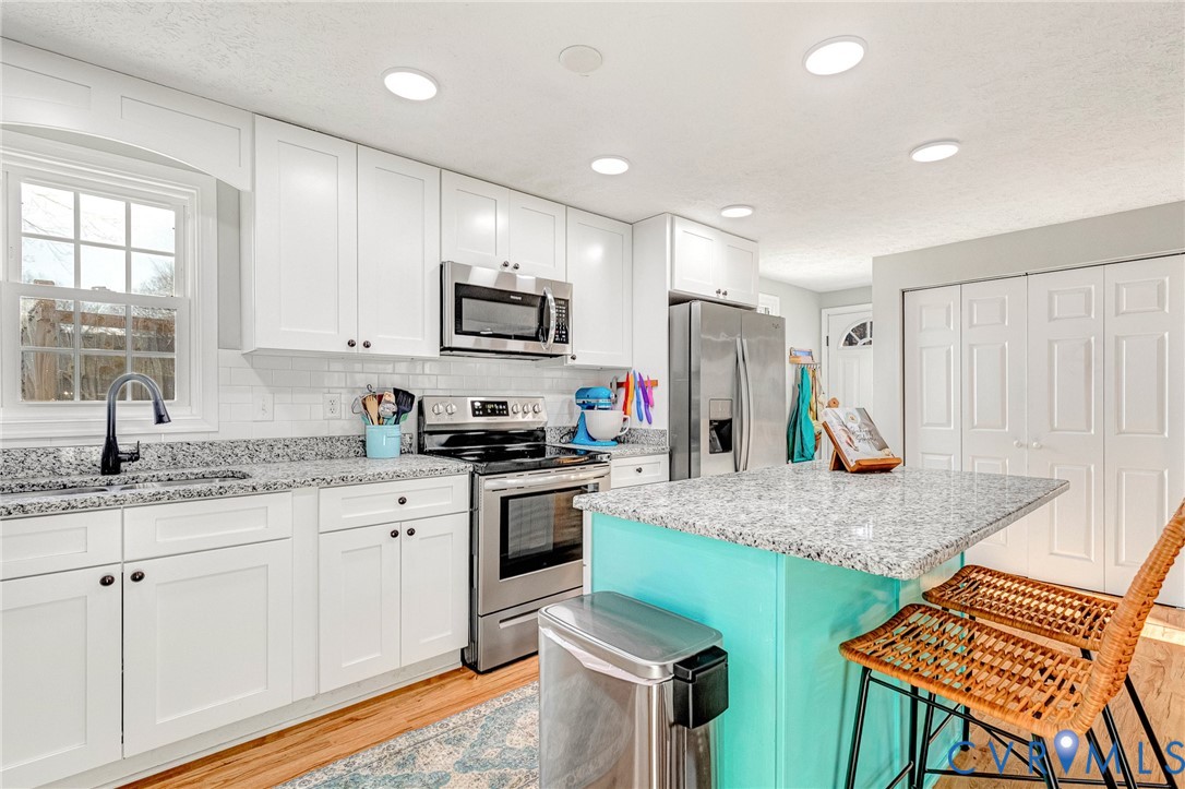 16004 Gary Avenue Chester, VA 23831 - Photo 5 of 26 a kitchen with stainless steel appliances granite countertop a stove top oven a sink dishwasher and a refrigerator with wooden floor