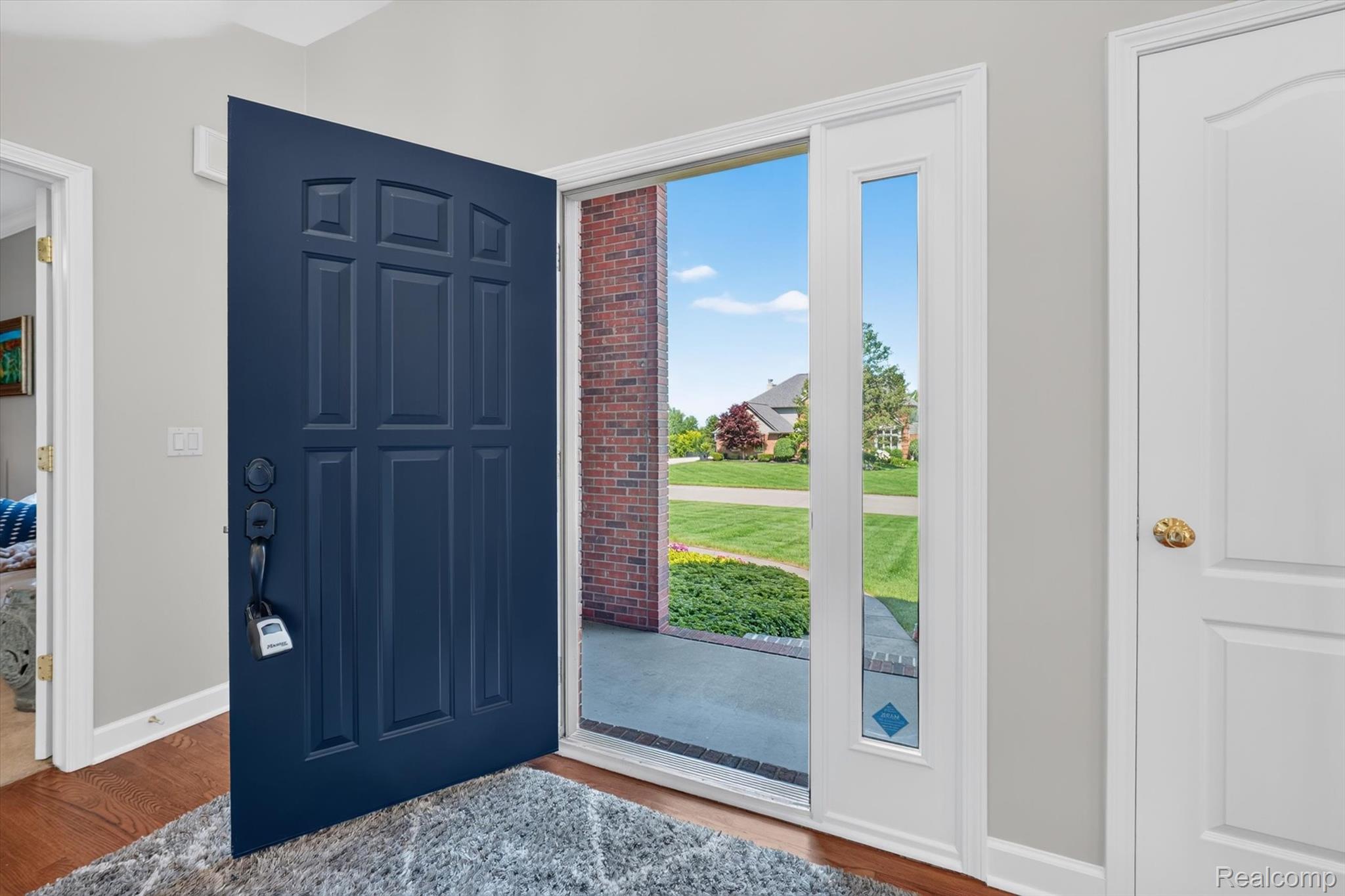 3804 Elk Drive Rochester, MI 48306 - Photo 6 of 75 Panel-paneled front door with a side-light window, wood-finish flooring, and light gray wall paint