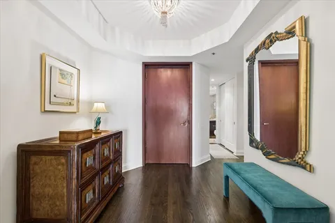 a view of a hallway with entryway wooden floor and front door