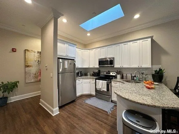 a kitchen with granite countertop stainless steel appliances and wooden cabinets