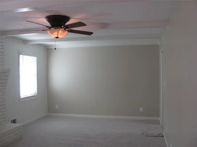 an empty room with a chandelier fan