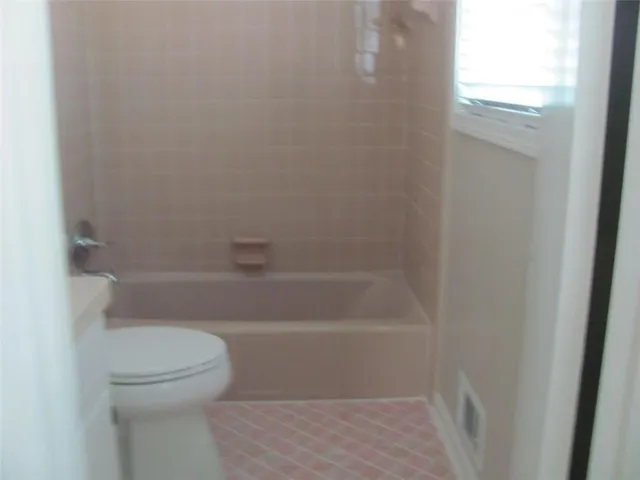 a white toilet sitting next to a bath tub