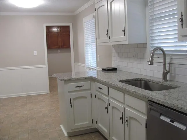 a kitchen with granite countertop white cabinets and sink
