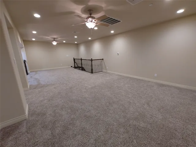 an empty room with a ceiling fan and a window