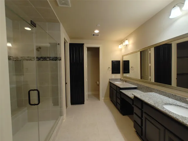a bathroom with a granite countertop sink toilet and mirror