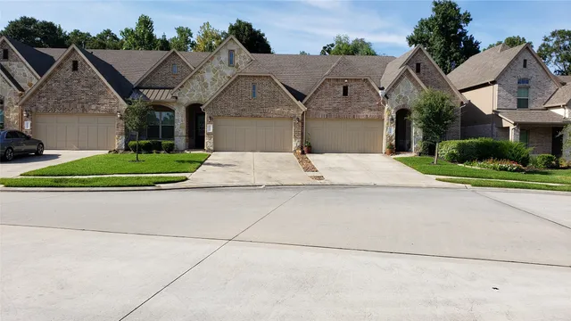 a view of backyard with a large tree and wooden fence