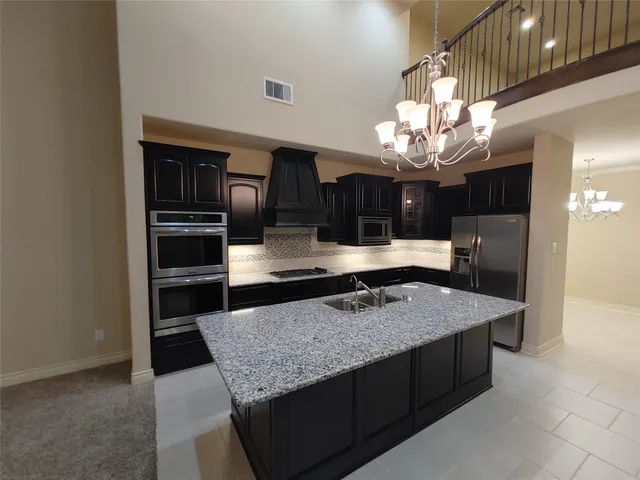 a kitchen with stainless steel appliances granite countertop a sink refrigerator and cabinets
