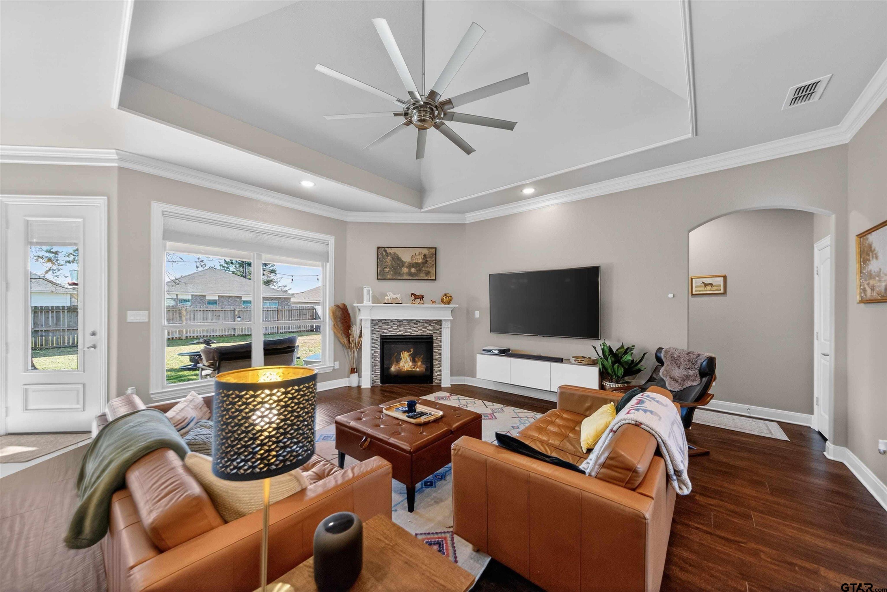 a living room with furniture a fireplace and a flat screen tv
