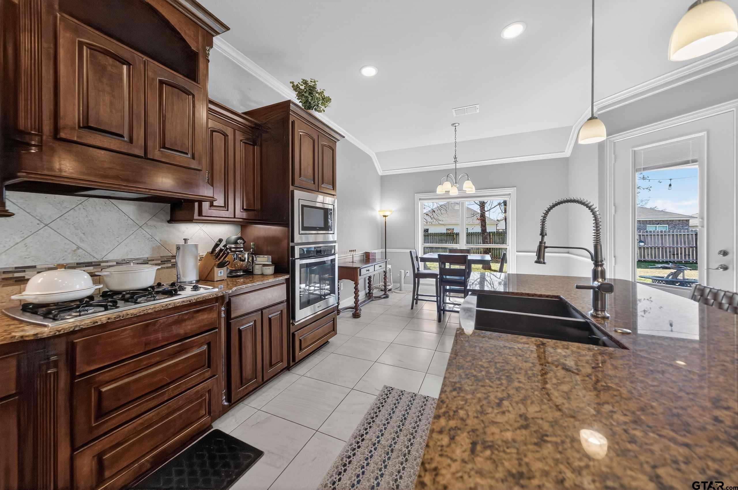 2202 Rana Park Flint, TX 75762 - Photo 17 of 47 a kitchen with granite countertop a stove a sink and a refrigerator