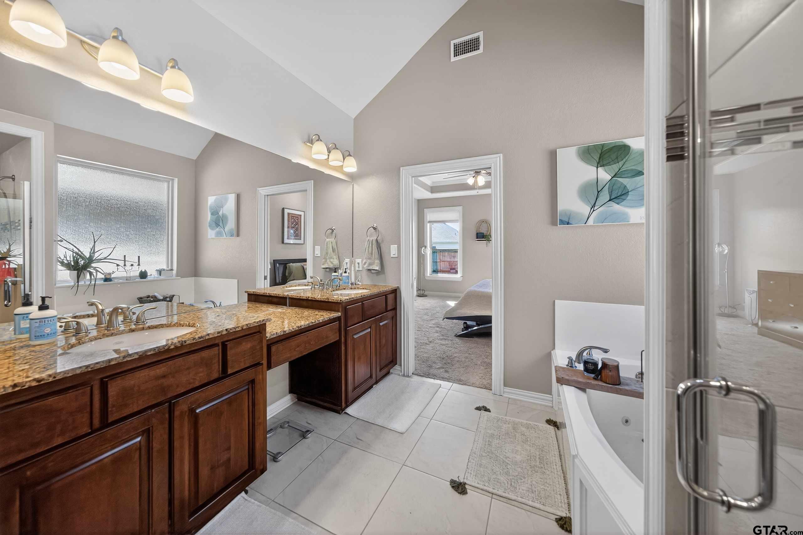 2202 Rana Park Flint, TX 75762 - Photo 31 of 47 a large bathroom with a granite countertop double vanity sink a mirror and a bathtub