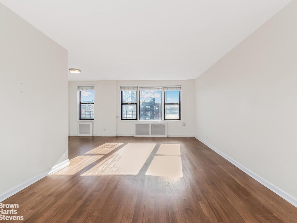 645 West 239th Street, Unit 6C Bronx, NY 10463 - Photo 2 of 18 an empty room with wooden floor and windows