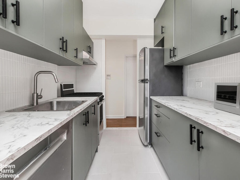 645 West 239th Street, Unit 6C Bronx, NY 10463 - Photo 7 of 18 a kitchen with stainless steel appliances granite countertop a sink and a refrigerator