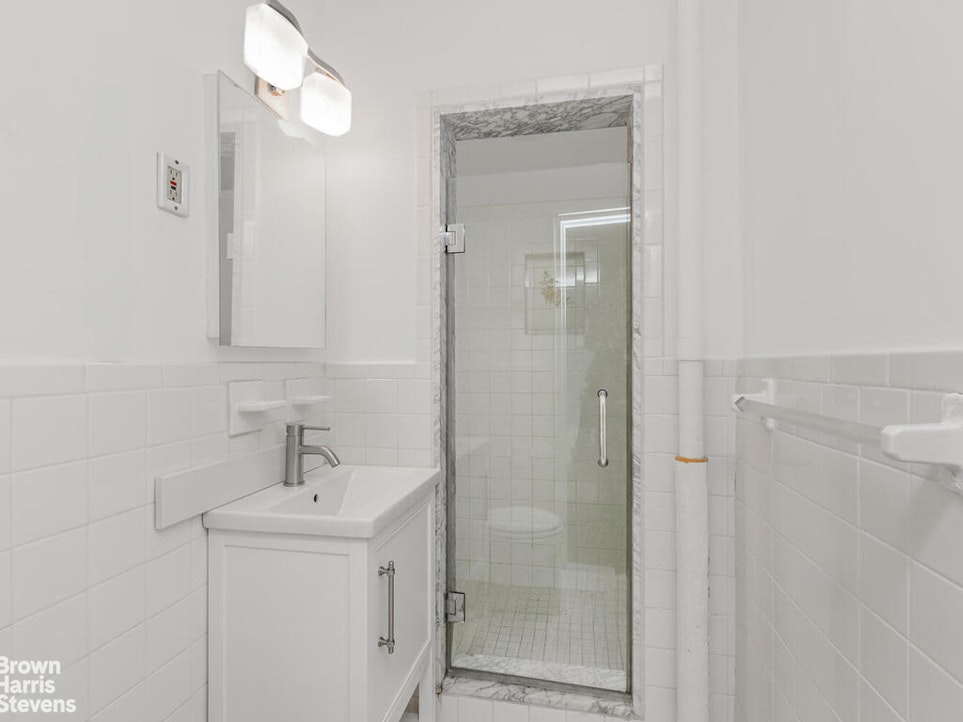 645 West 239th Street, Unit 6C Bronx, NY 10463 - Photo 9 of 18 a bathroom with a shower a sink and mirror