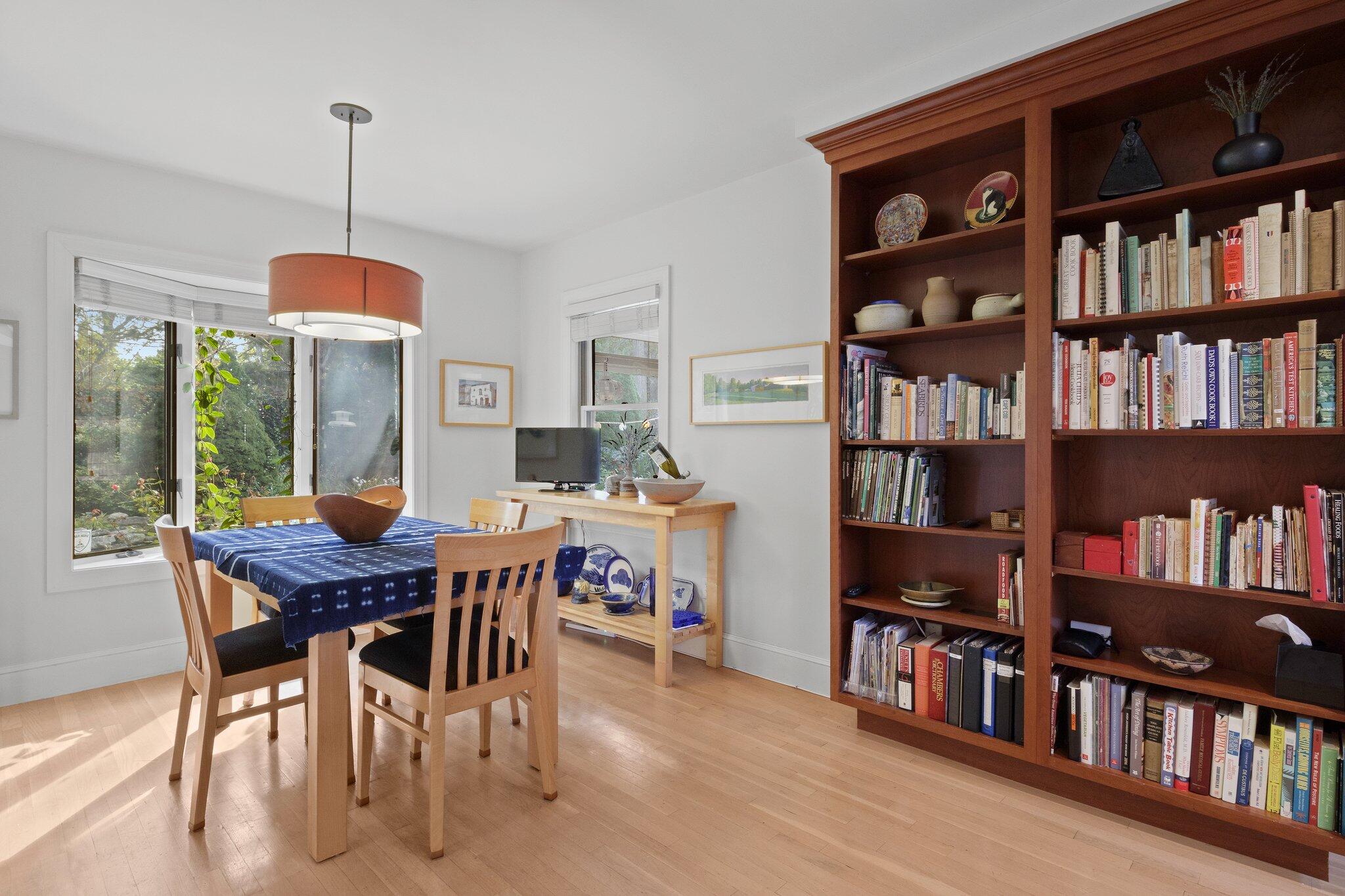 135 Locust Road Eastham, MA 02642 - Photo 27 of 88 a dining room with furniture a book shelves and a book shelf