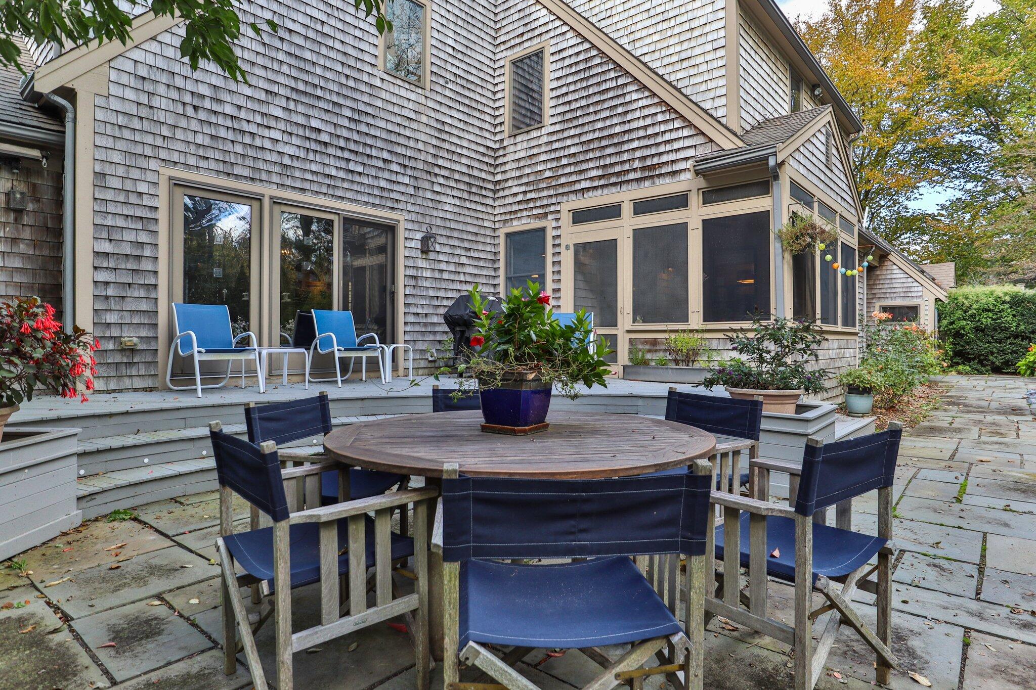 135 Locust Road Eastham, MA 02642 - Photo 78 of 88 a view of a patio with table and chairs potted plants and wooden fence