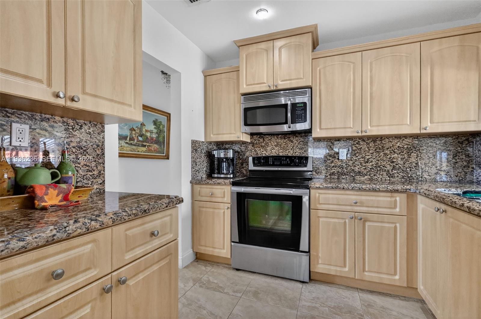 17841 Northwest 84th Court Hialeah, FL 33015 - Photo 26 of 76 a kitchen with granite countertop white cabinets stainless steel appliances and a counter space
