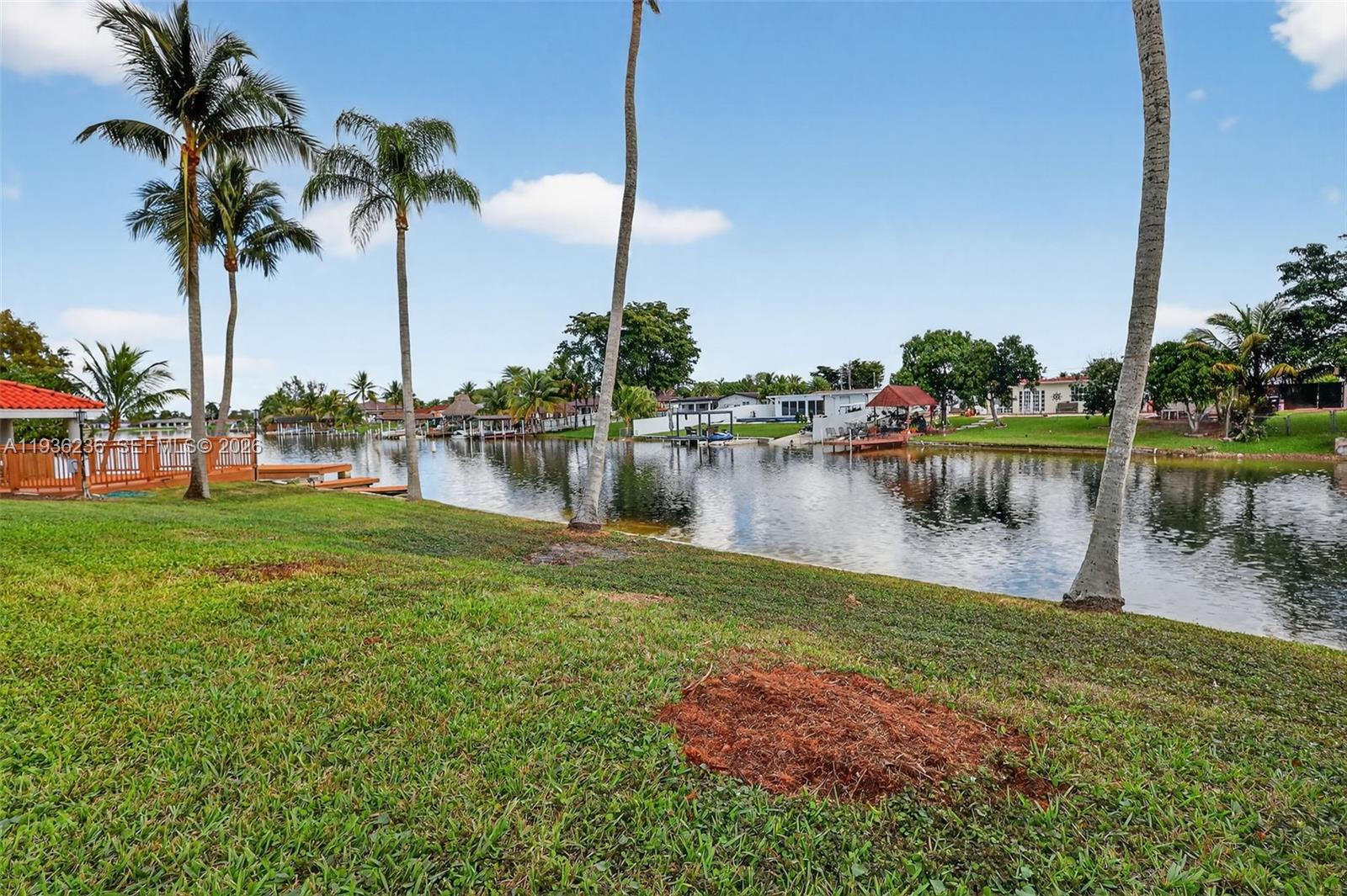 17841 Northwest 84th Court Hialeah, FL 33015 - Photo 50 of 76 a lake with palm trees next to a yard