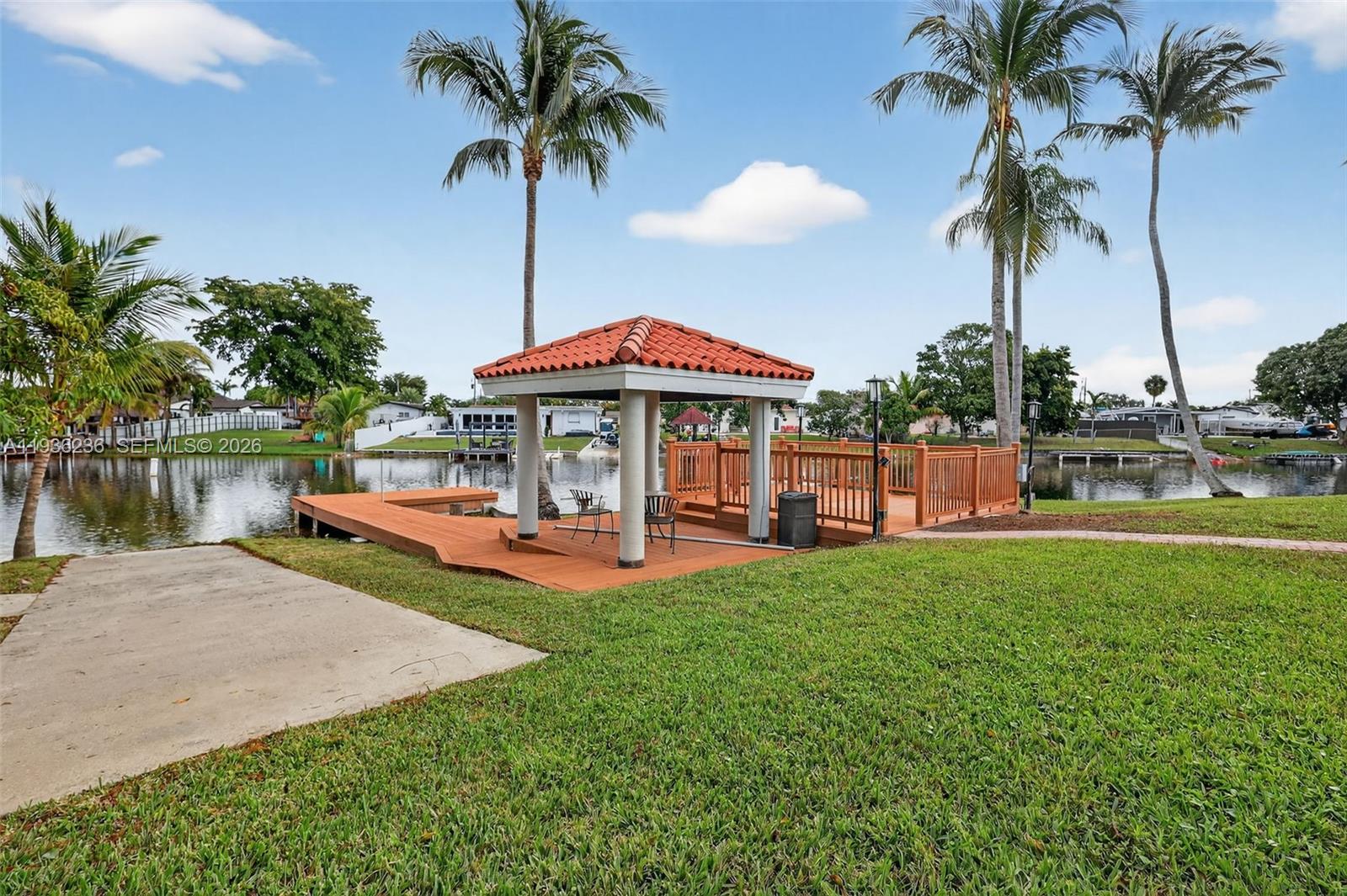 17841 Northwest 84th Court Hialeah, FL 33015 - Photo 55 of 76 a view of a swimming pool with a table and chairs under an umbrella