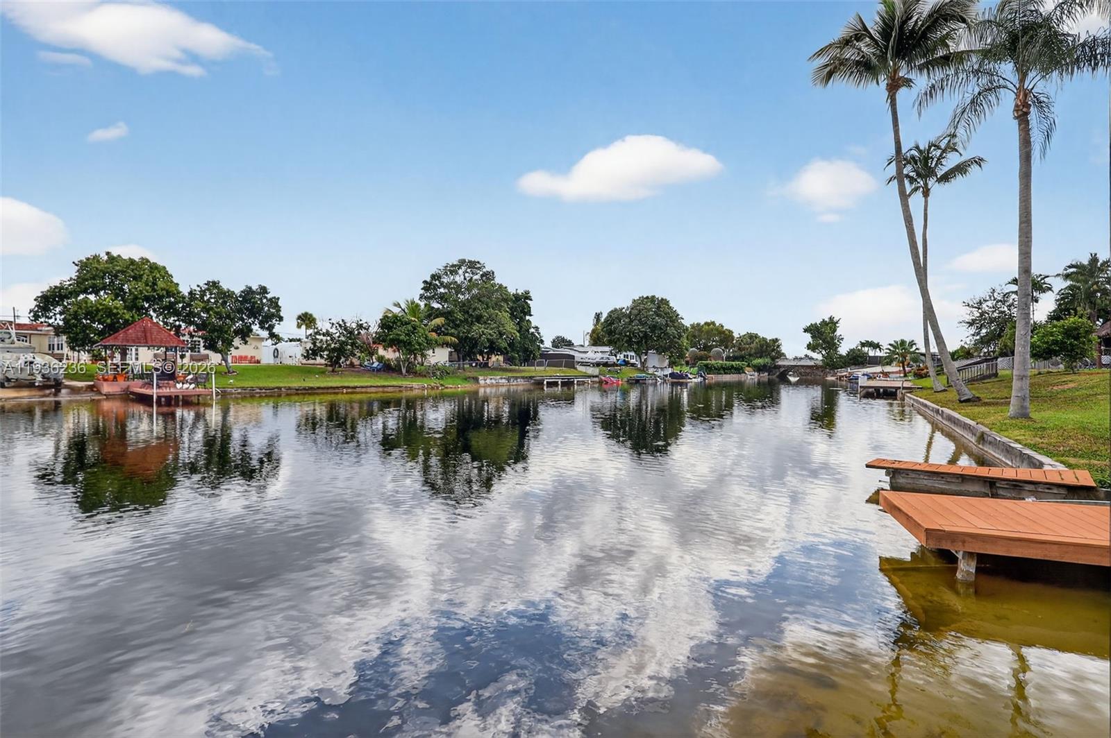 17841 Northwest 84th Court Hialeah, FL 33015 - Photo 60 of 76 a view of a lake with boats and palm trees