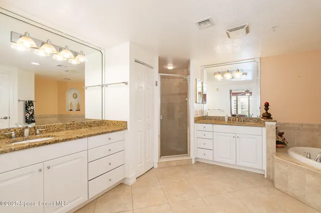 a spacious bathroom with a double vanity sink mirror and bathtub