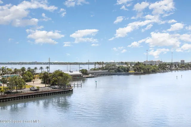 a view of an ocean with boats and trees in the background