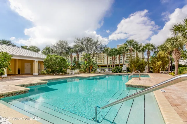 a view of a swimming pool with a patio and fire pit