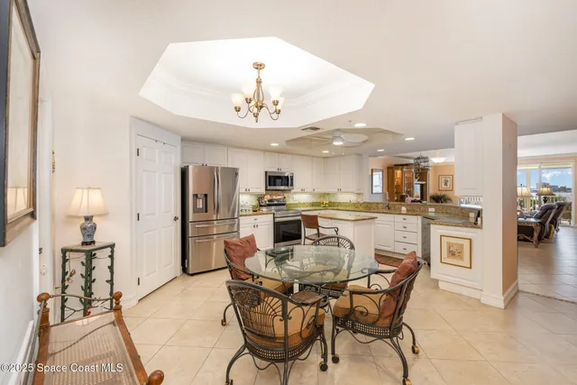 a kitchen with stainless steel appliances granite countertop a stove top oven a sink a stove a dining table and chairs