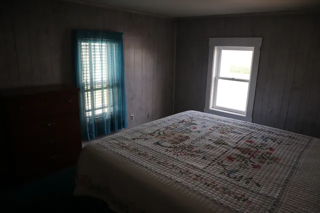 a bedroom with a bed and a window