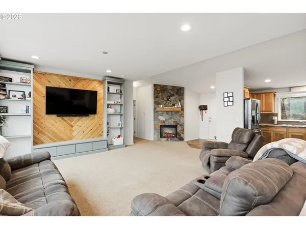 a living room with furniture a large window and flat screen tv