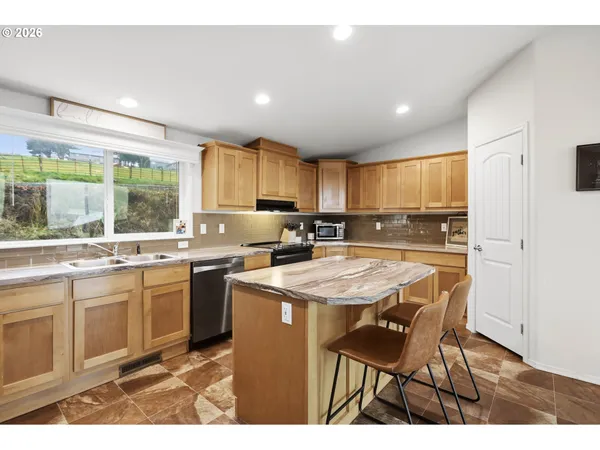 a kitchen with kitchen island granite countertop wooden cabinets and stainless steel appliances