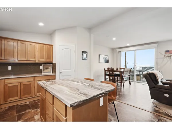 a kitchen with stainless steel appliances granite countertop a table chairs sink refrigerator and cabinets