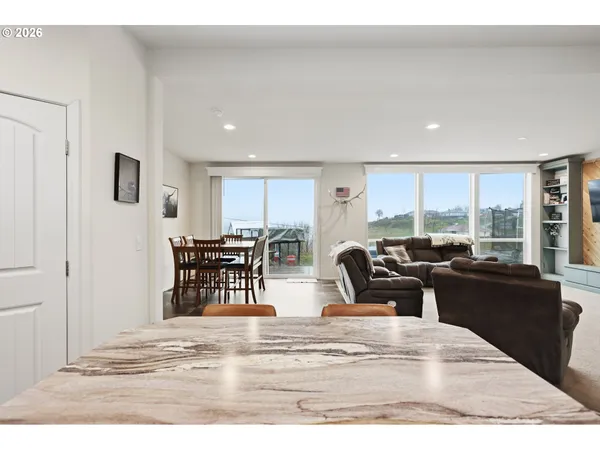a kitchen with granite countertop a table chairs microwave and cabinets