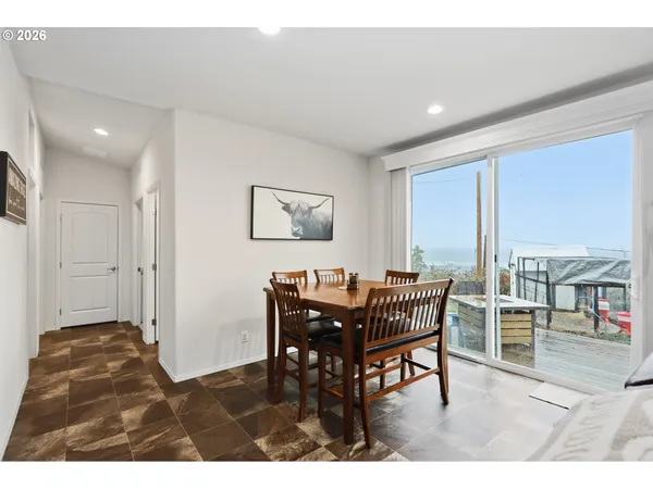 a view of a dining room with furniture a kitchen and chandelier