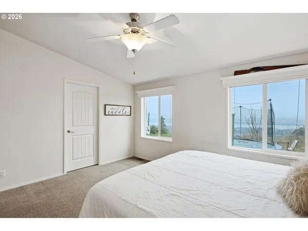 a living room with furniture a flat screen tv and a refrigerator