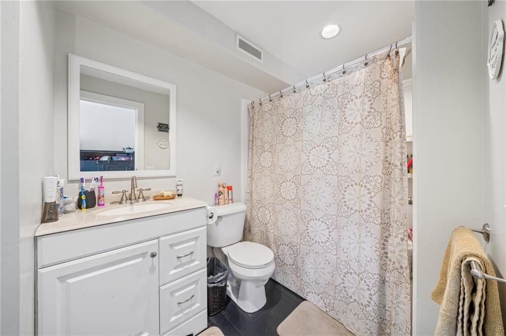 107 Hatfield Street Jefferson, PA 15344 - Photo 28 of 35 a bathroom with a toilet sink a mirror and shower curtain