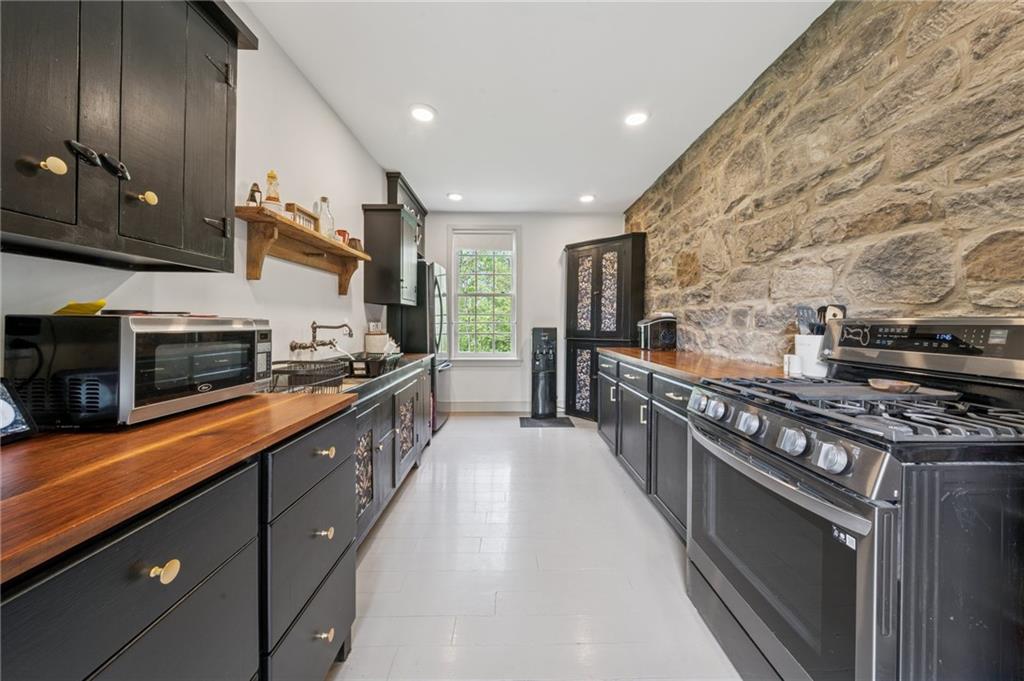 107 Hatfield Street Jefferson, PA 15344 - Photo 7 of 35 a large kitchen with stainless steel appliances granite countertop a stove a sink and a refrigerator