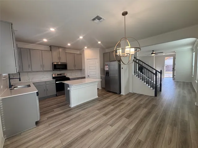 a kitchen with stove a refrigerator and a sink