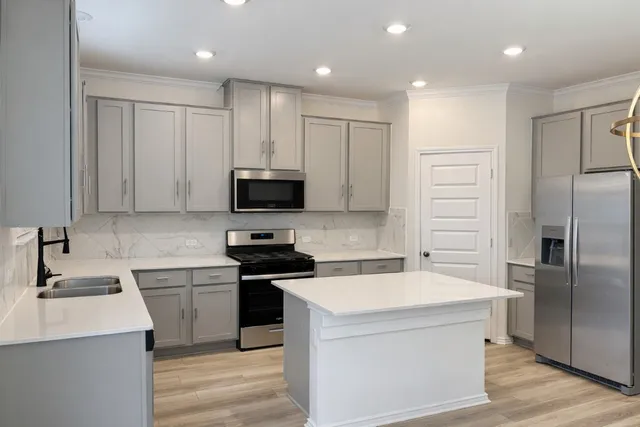 a kitchen with a sink appliances and cabinets