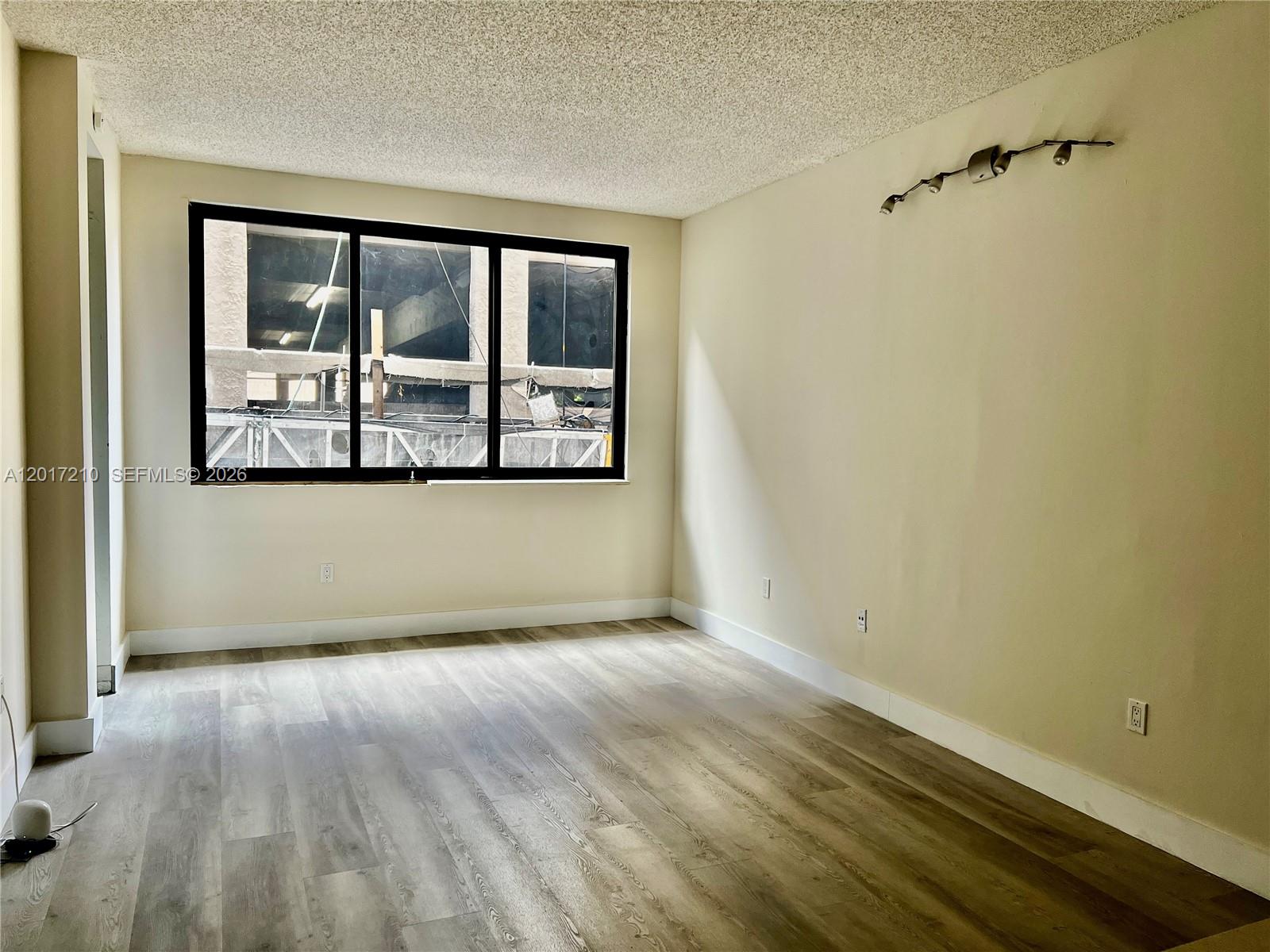 540 Brickell Key Drive, Unit 218 Miami, FL 33131 - Photo 5 of 12 an empty room with wooden floor and windows