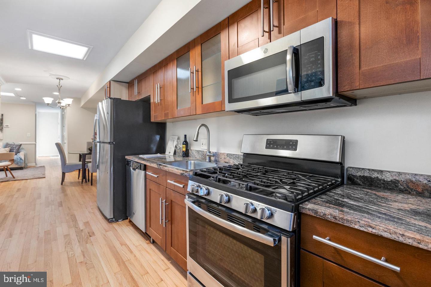 1229 18th Street Northeast, Unit 201 Washington, DC 20002 - Photo 6 of 14 a kitchen with stainless steel appliances granite countertop a stove and a microwave