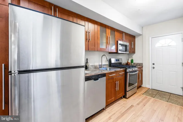 a kitchen with stainless steel appliances a refrigerator sink and cabinets