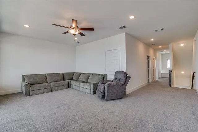a living room with furniture and a ceiling fan
