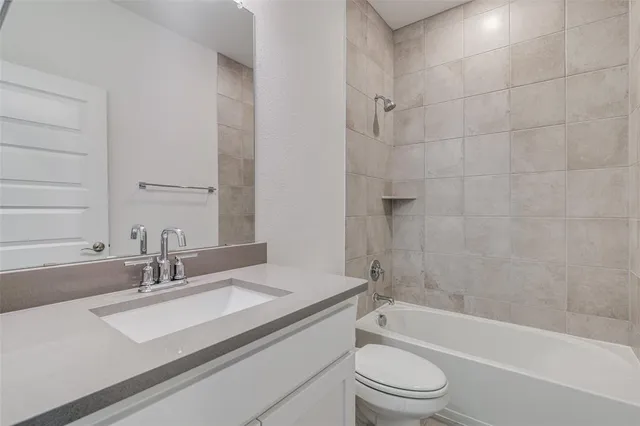 a bathroom with a granite countertop sink a toilet and bathtub