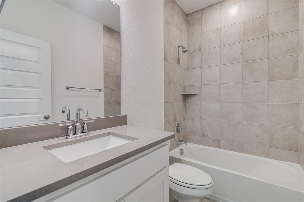 722 Resort Drive Rowlett, TX 75088 - Photo 19 of 24 a bathroom with a granite countertop sink a toilet and bathtub