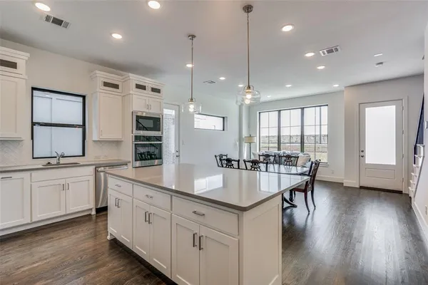 a large kitchen with kitchen island a large island in it