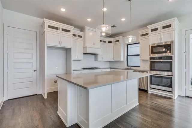 a large kitchen with stainless steel appliances kitchen island granite countertop a large stove a sink and a refrigerator